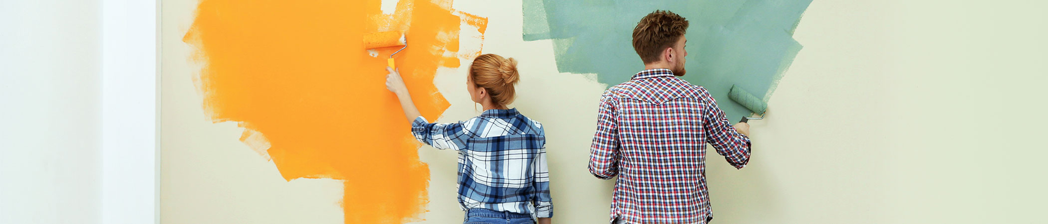 Young married couple painting a wall